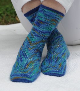 Meandering Mesh - Panels of lace rise diagonally up to the left from the sole, making them meander on the foot but settle into orderly spirals on the leg.